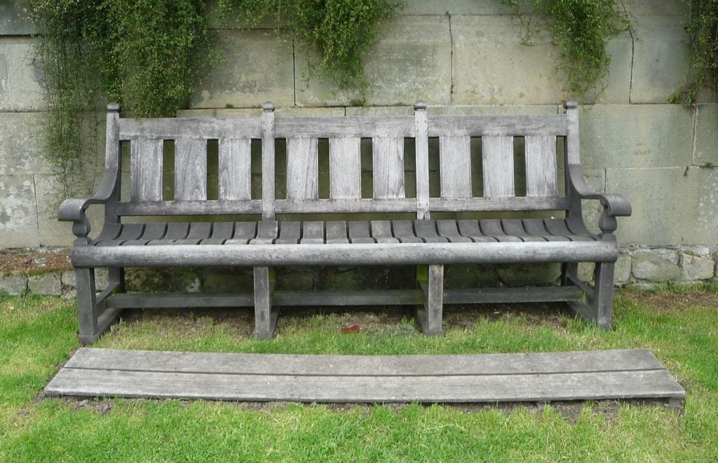 Teak garden bench at Harewood House in Harewood, West Yorkshire. Looking after