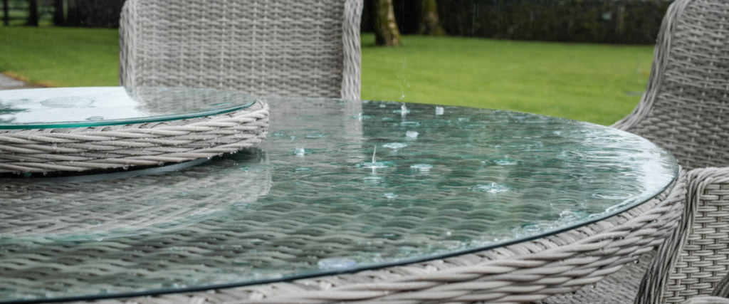 A picture of a rattan dining set being rained on: garden furniture trends 