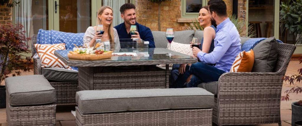 A picture of a group of people enjoying some time on a rattan dining set: outdoor party seating ideas 