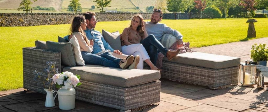 A picture of two couples lounging on rattan furniture in the garden: outdoor furniture features